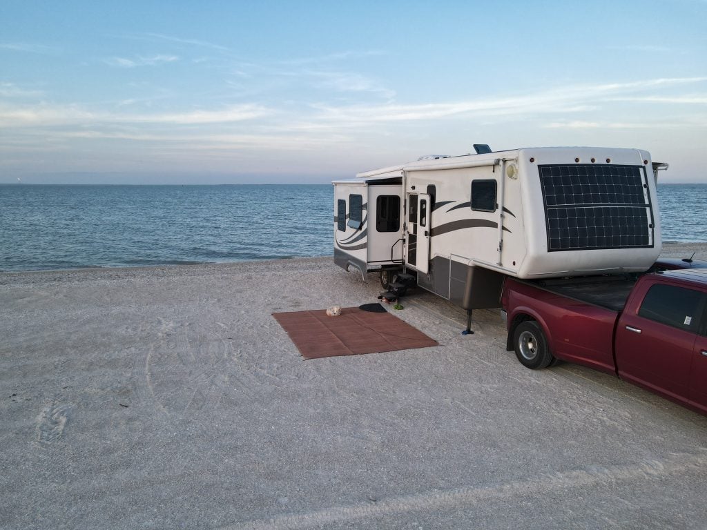 rv outdoor rug in front of fifth wheel on beach