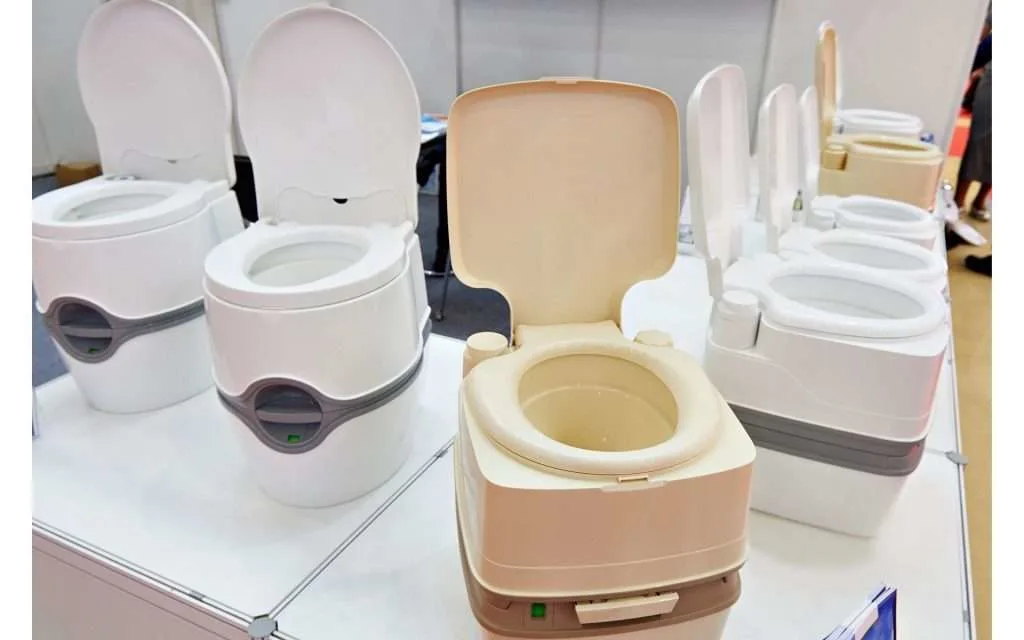 line up of portable toilets of various shapes sizes and colors