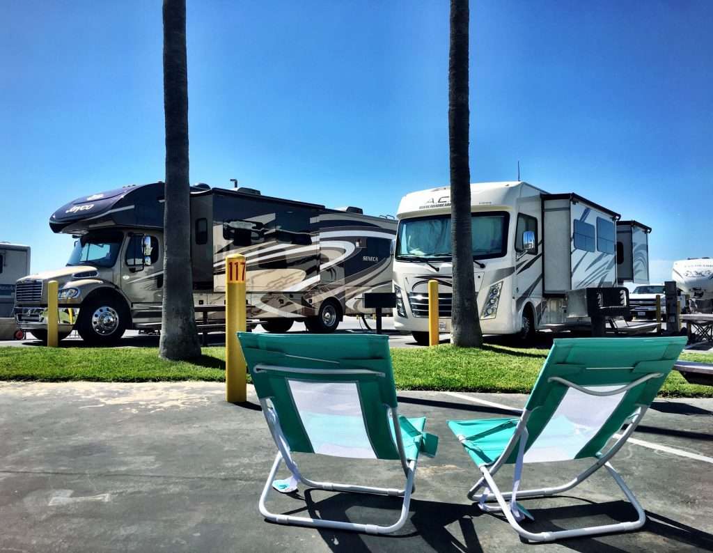 2 lawn chairs set up in front of an RV park. 