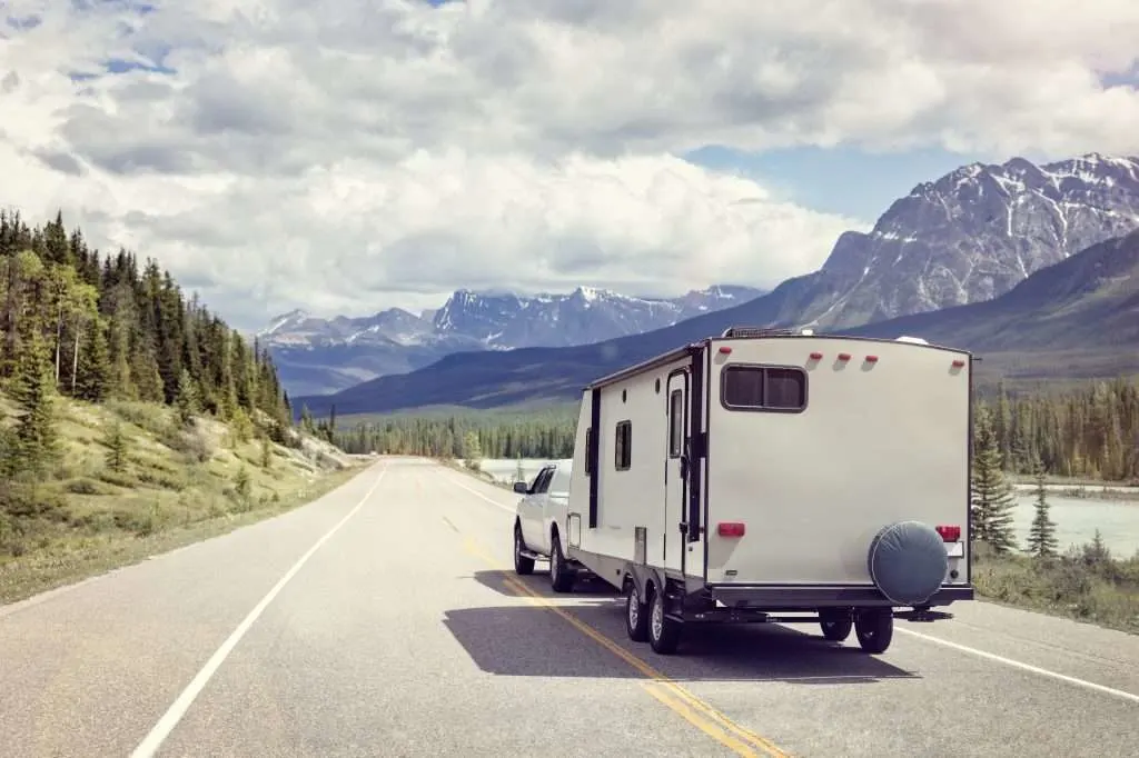 RV driving down road in the mountains.