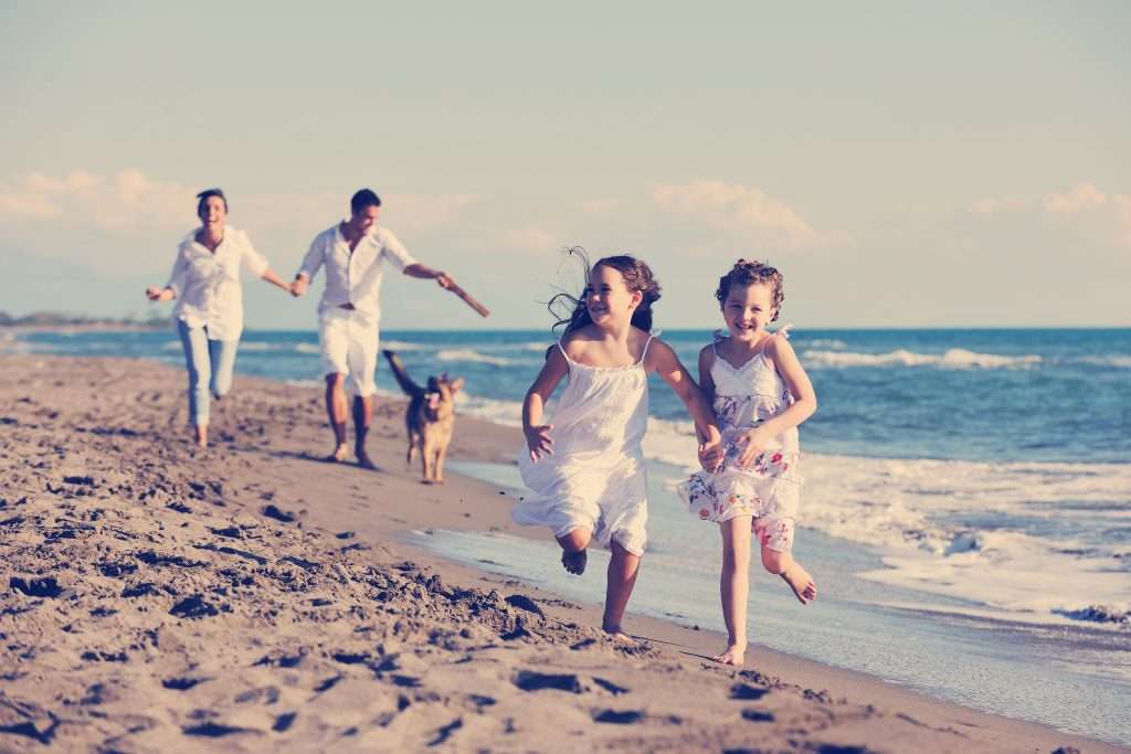 Happy family running on the beach in Port Aransas.