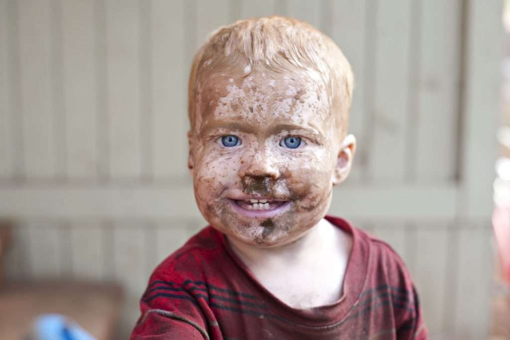 Little boy with dirt all over his face.