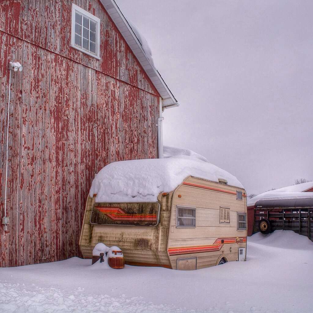 RV without a cover or a skirt in the freezing snow.