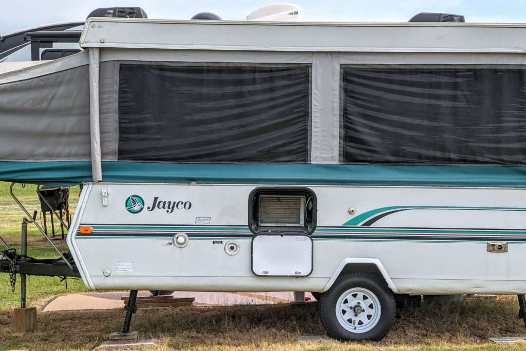 Popup camper with window air conditioner installed in storage