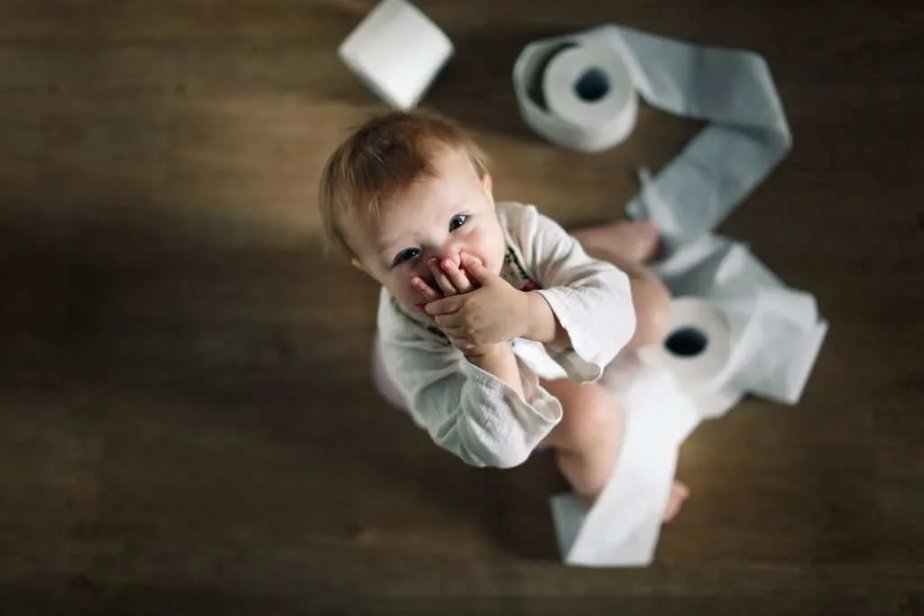 Little child wrapped in toilet paper.