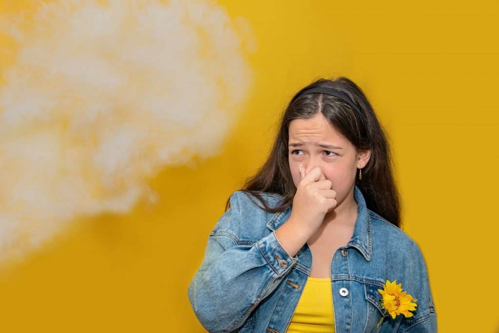 Girl plugging her nose from a smell.