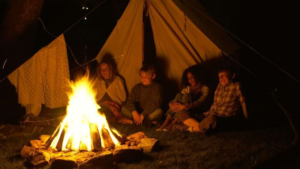 kids listening to ghost stories around a campfire