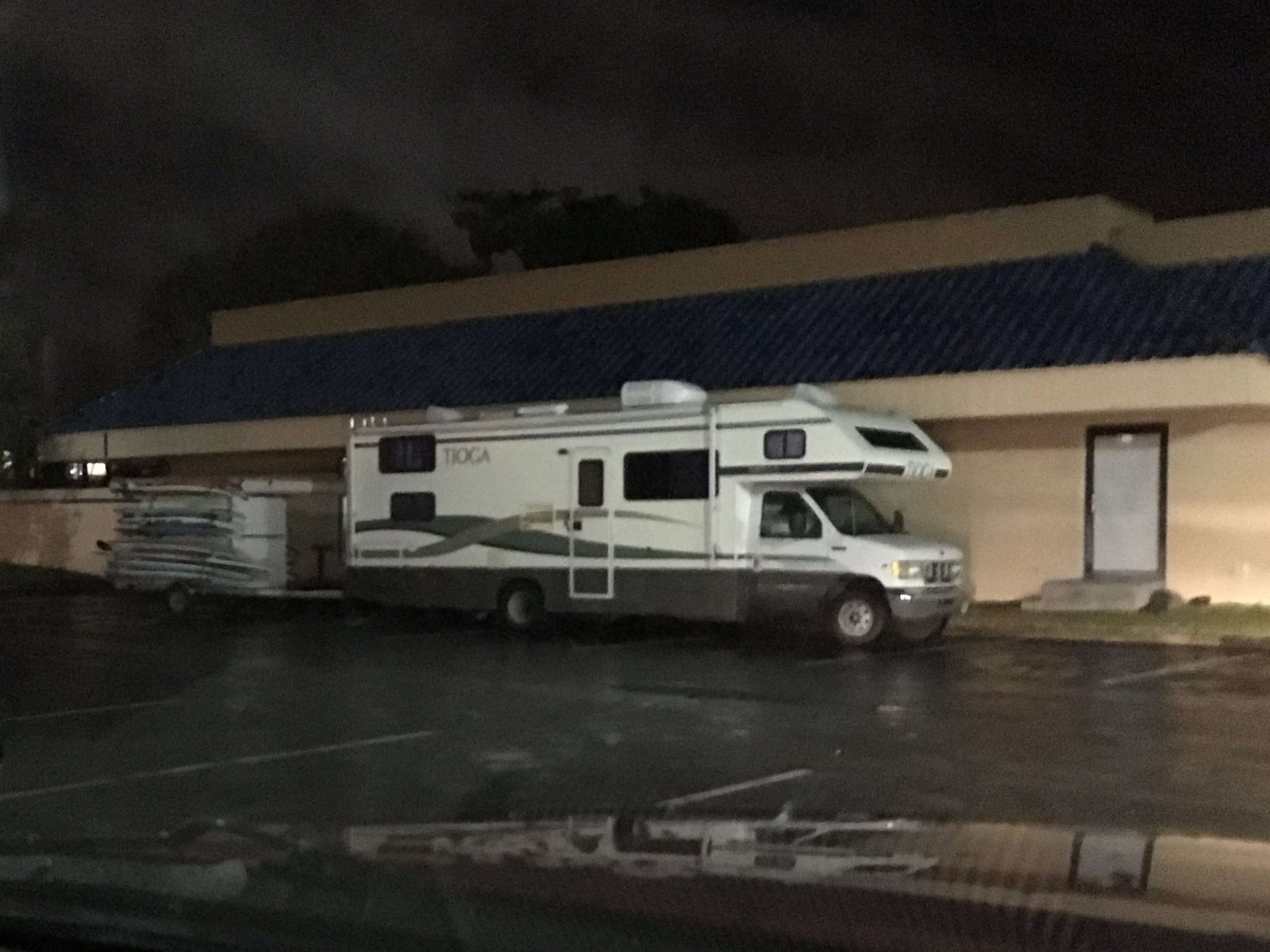 RV parked in parking lot at night