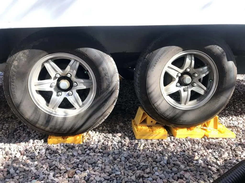 Camper tires propped up with wheel chocks.