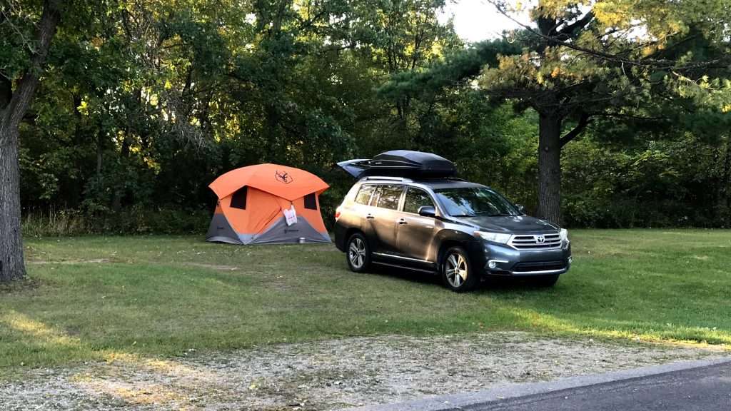 An SUV parked in front of a tent