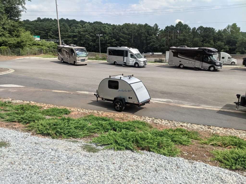 Small camper parked in parking lot.
