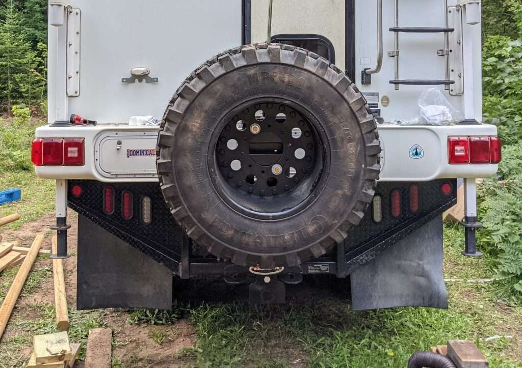 Truck camper with mud flaps installed.