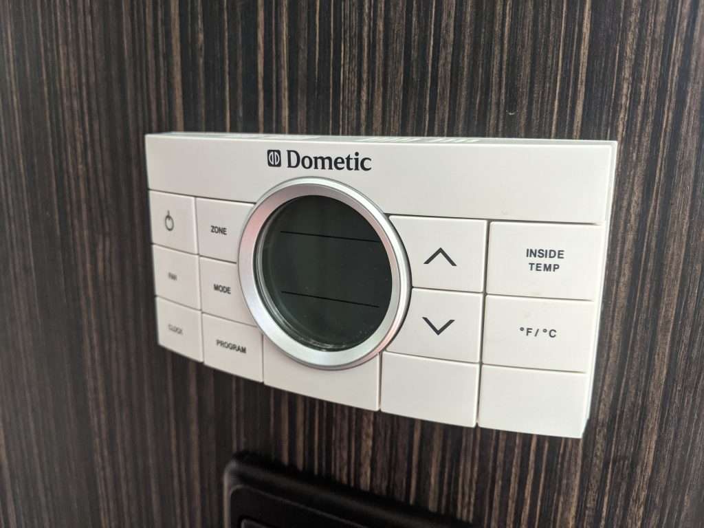 White Dometic RV thermostat.