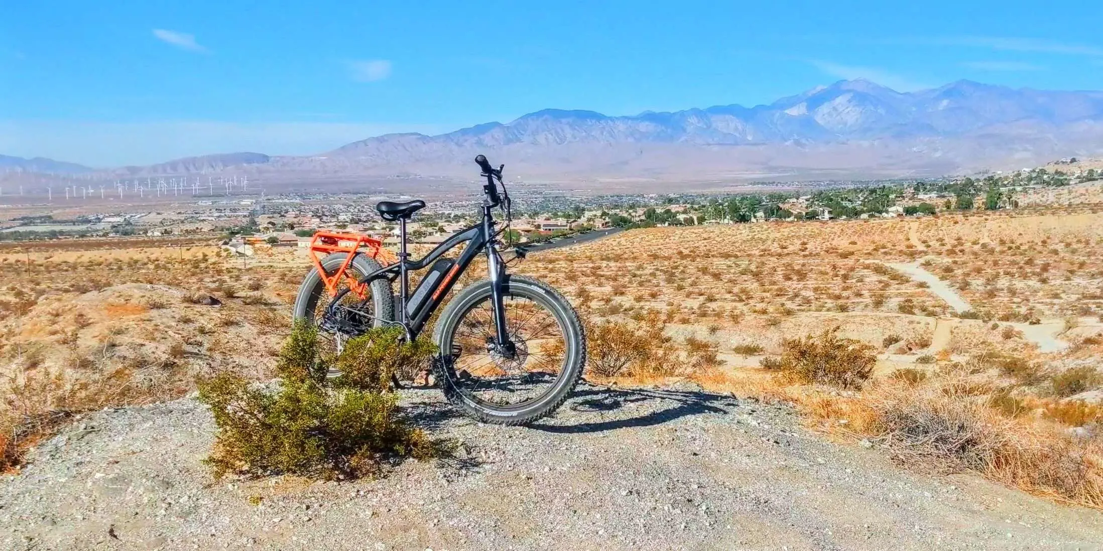 Bike parked in the desert in front of mountains.