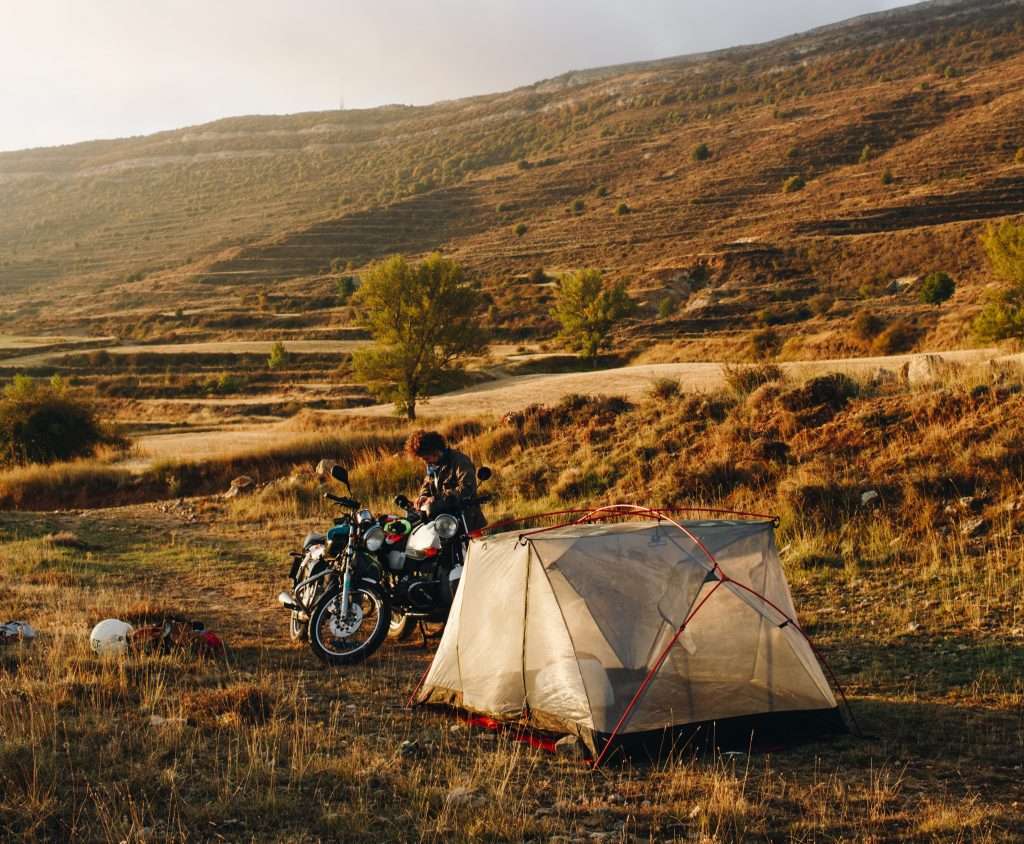 Motorcyclist camping in wild