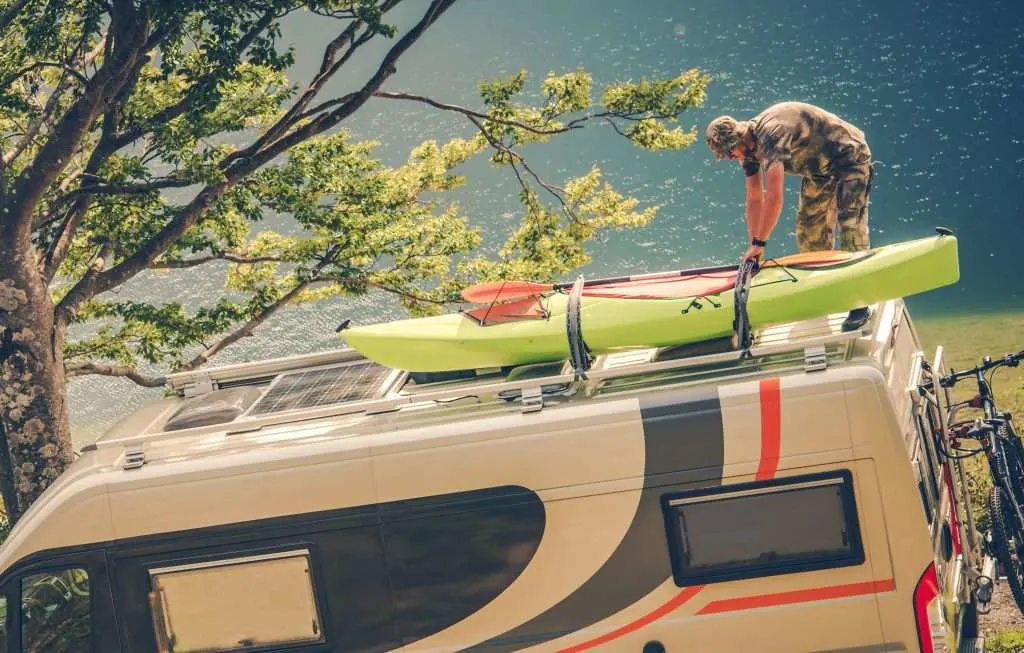 Man Installing Kayak on the RV Camper Van.
