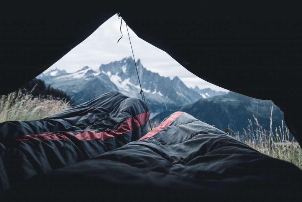 Two people in a tent sleeping in sleeping bags. 