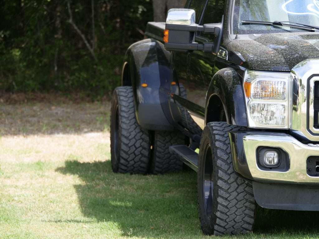 Close up of black truck parked on grass.