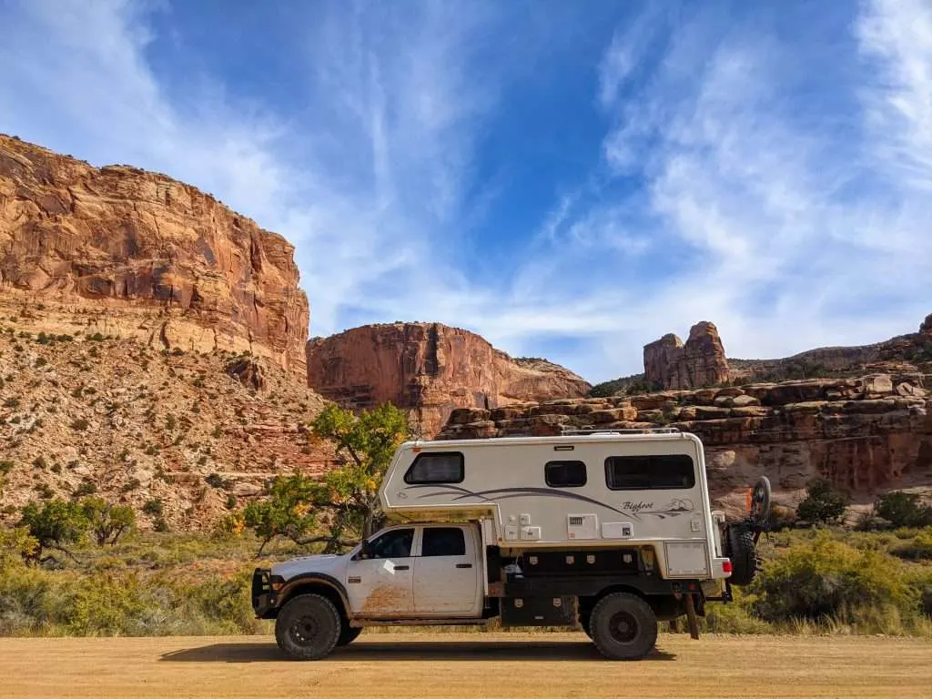 Truck camper parked in desert.