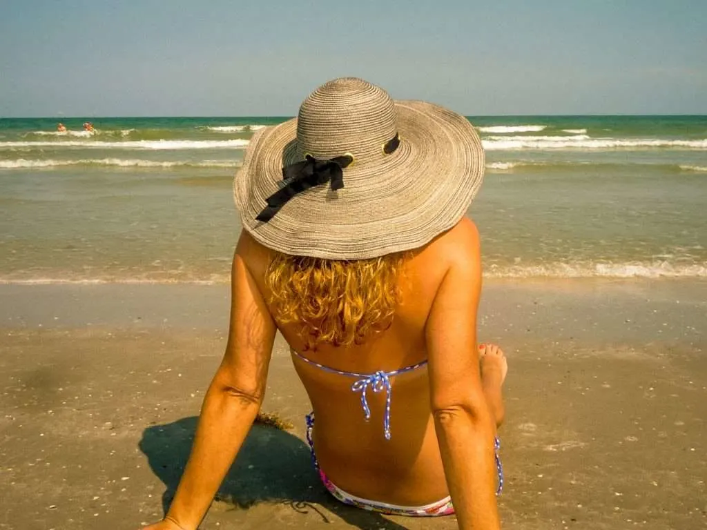 Woman sitting on beach in Texas.