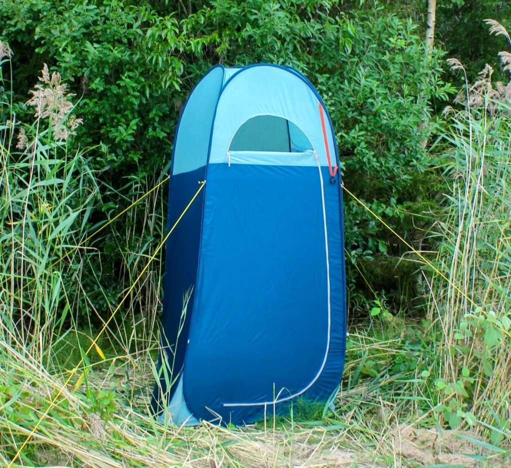 Pop-up shower tent set up in forest.
