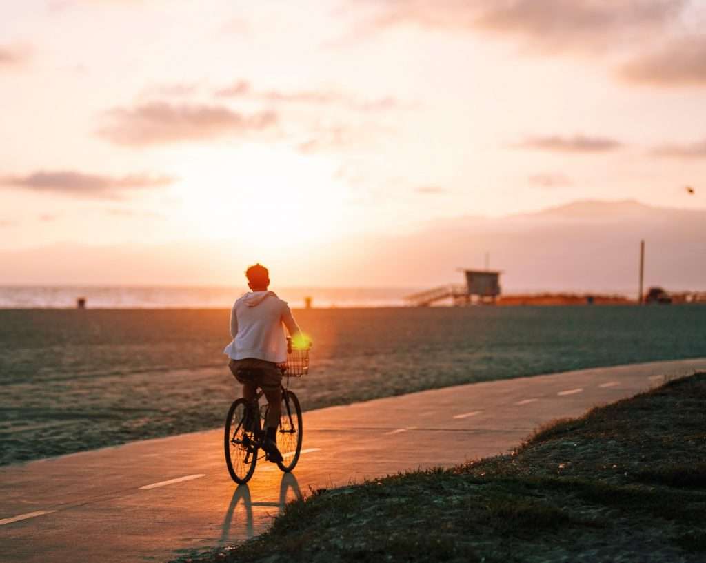 person biking at sunset along California coast.