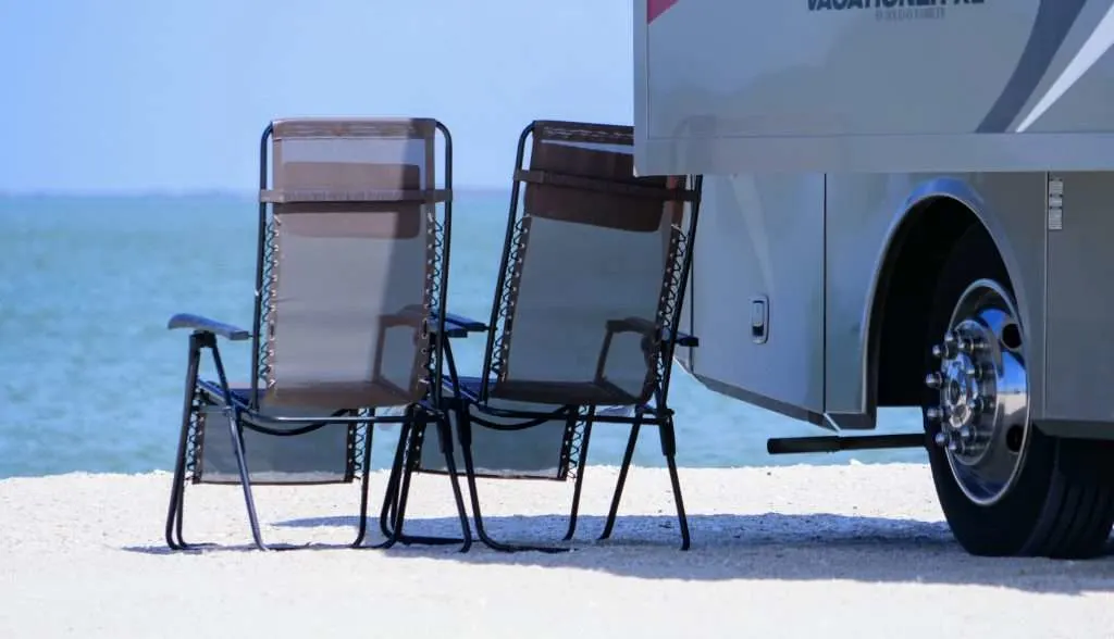 camping chairs by RV on the beach
