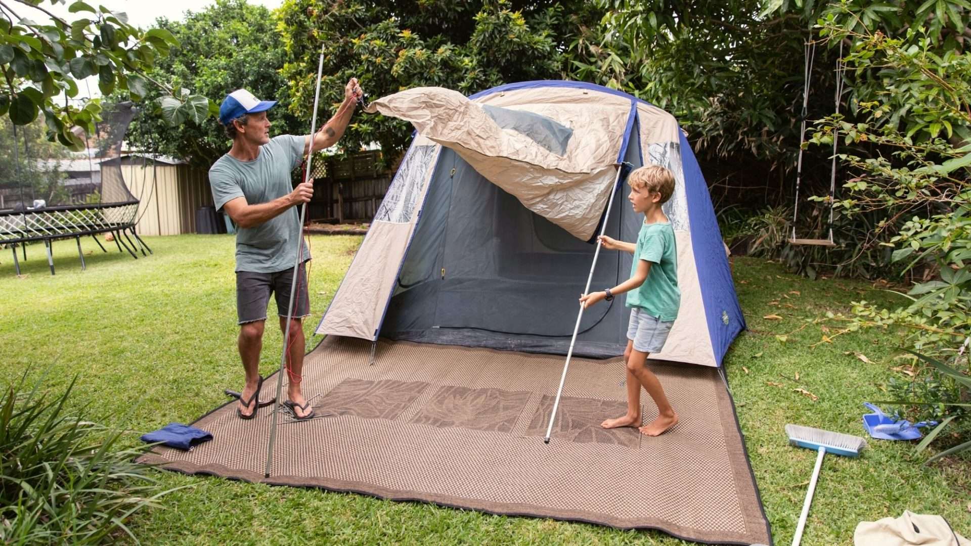father and son setting up a tent