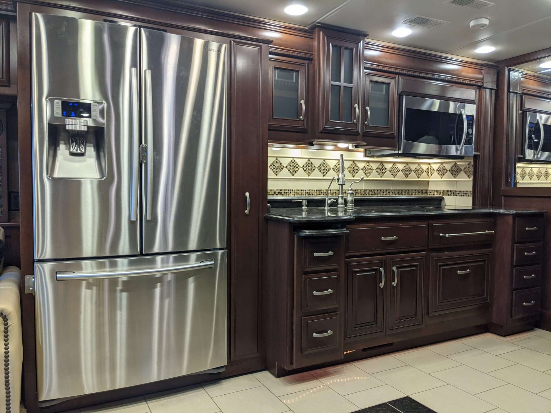 RV interior of kitchen with new fridge.