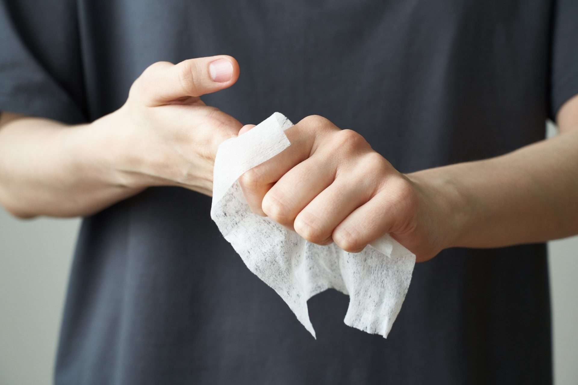 Person using wipe to clean hands.