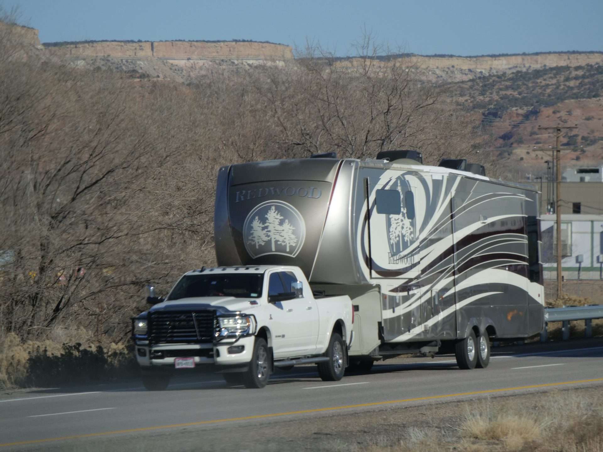 Truck towing fifth wheel camper.