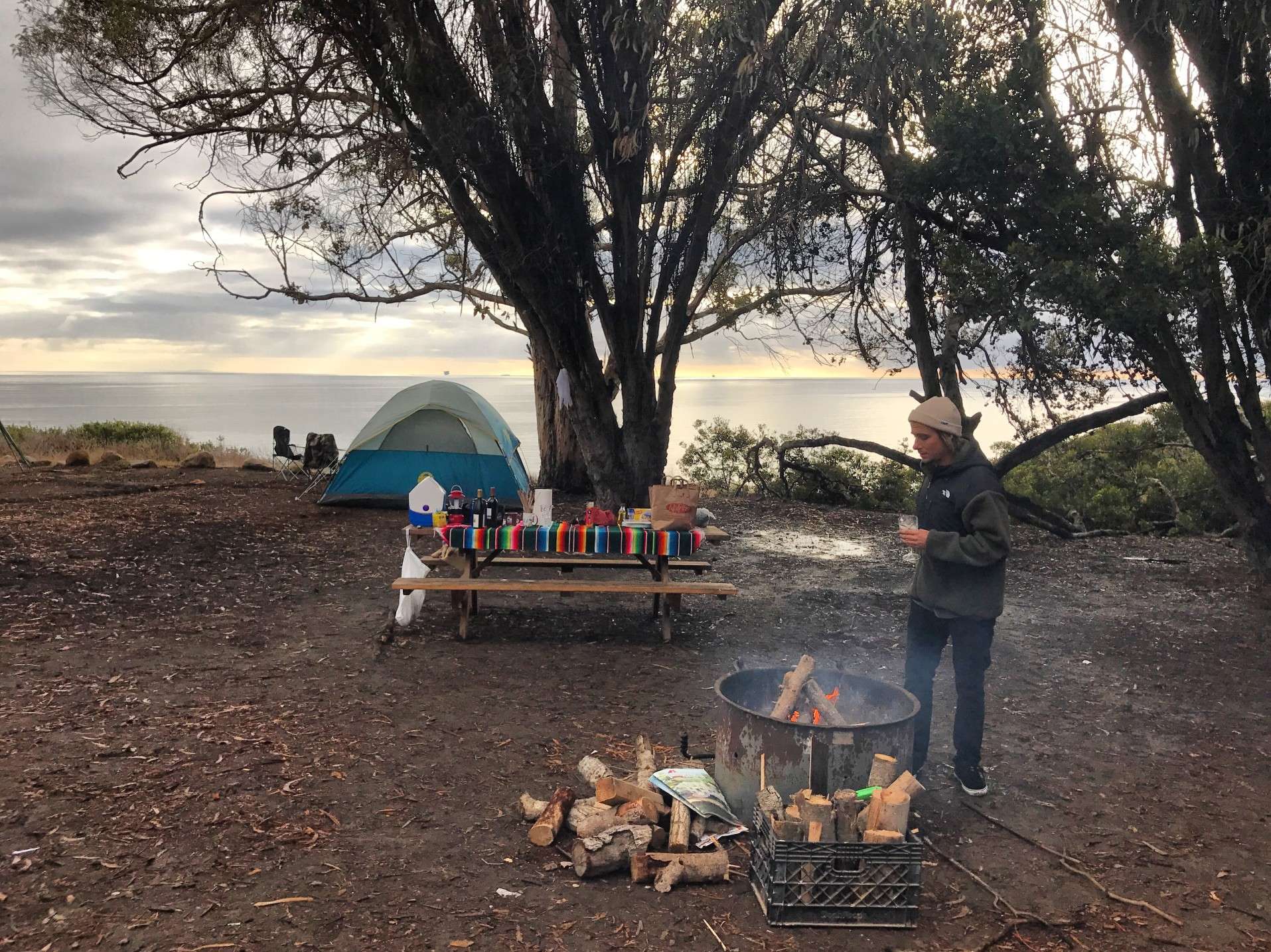 Woman cooking over campfire in California while camping.