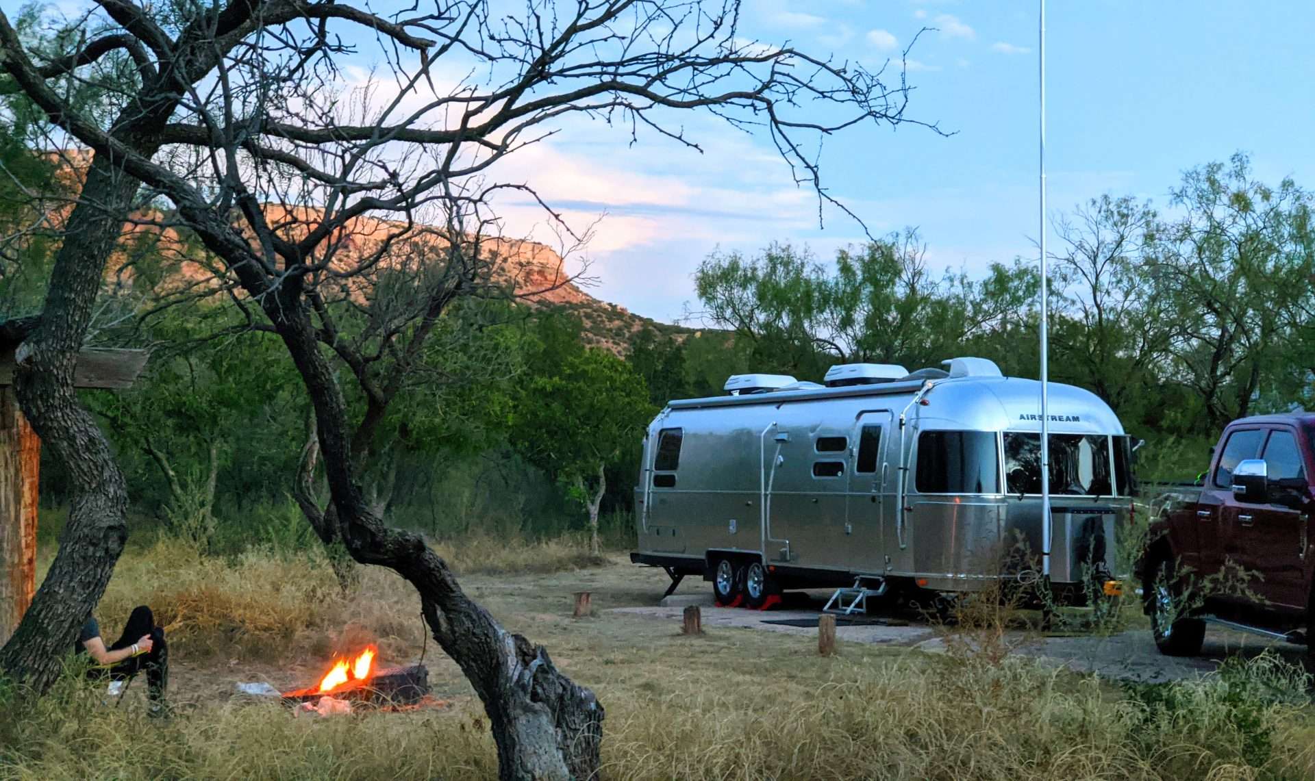 Airstream parked next to campfire.