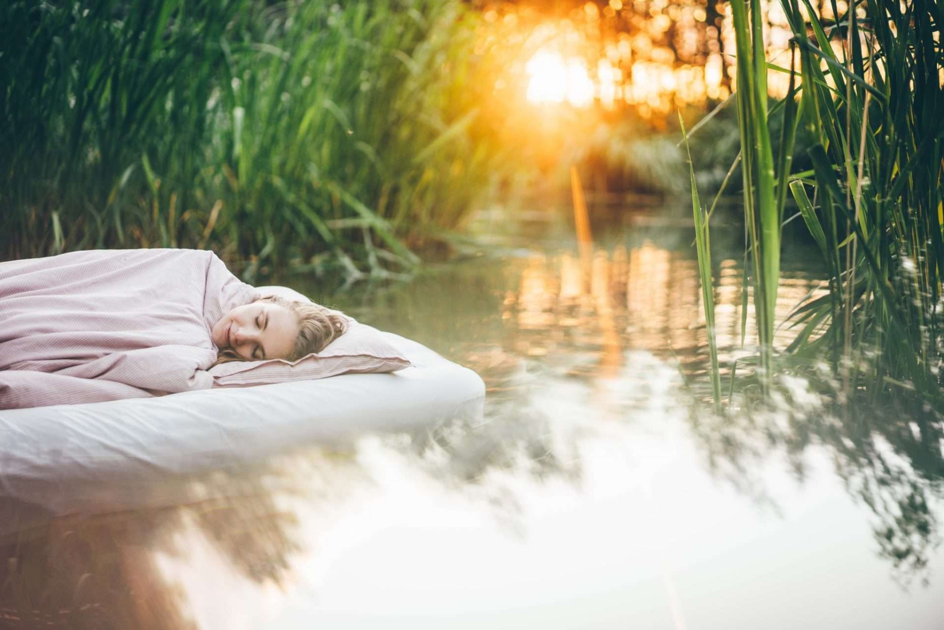 Woman napping on mattress on the water