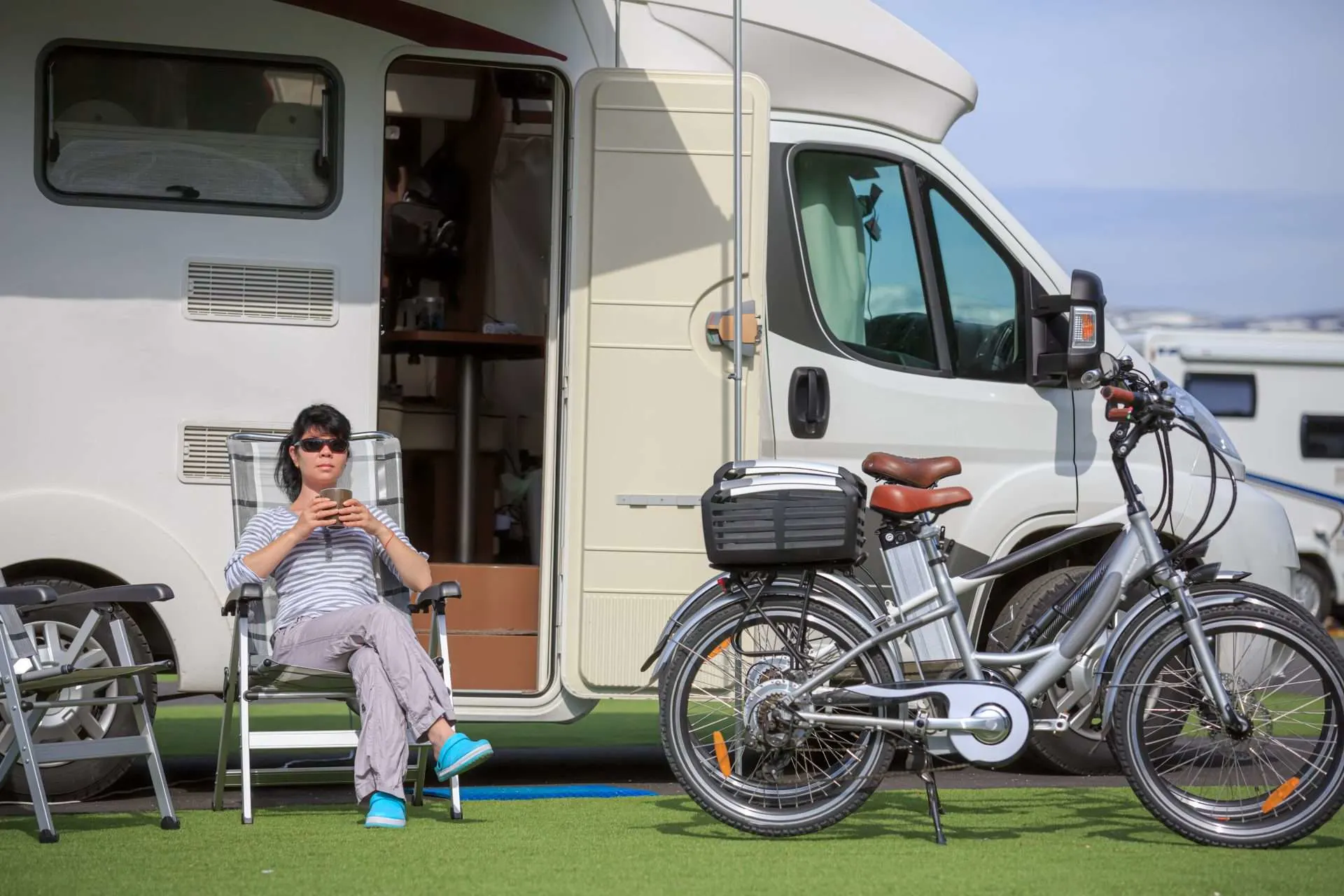 Woman drinking water in front of her RV.