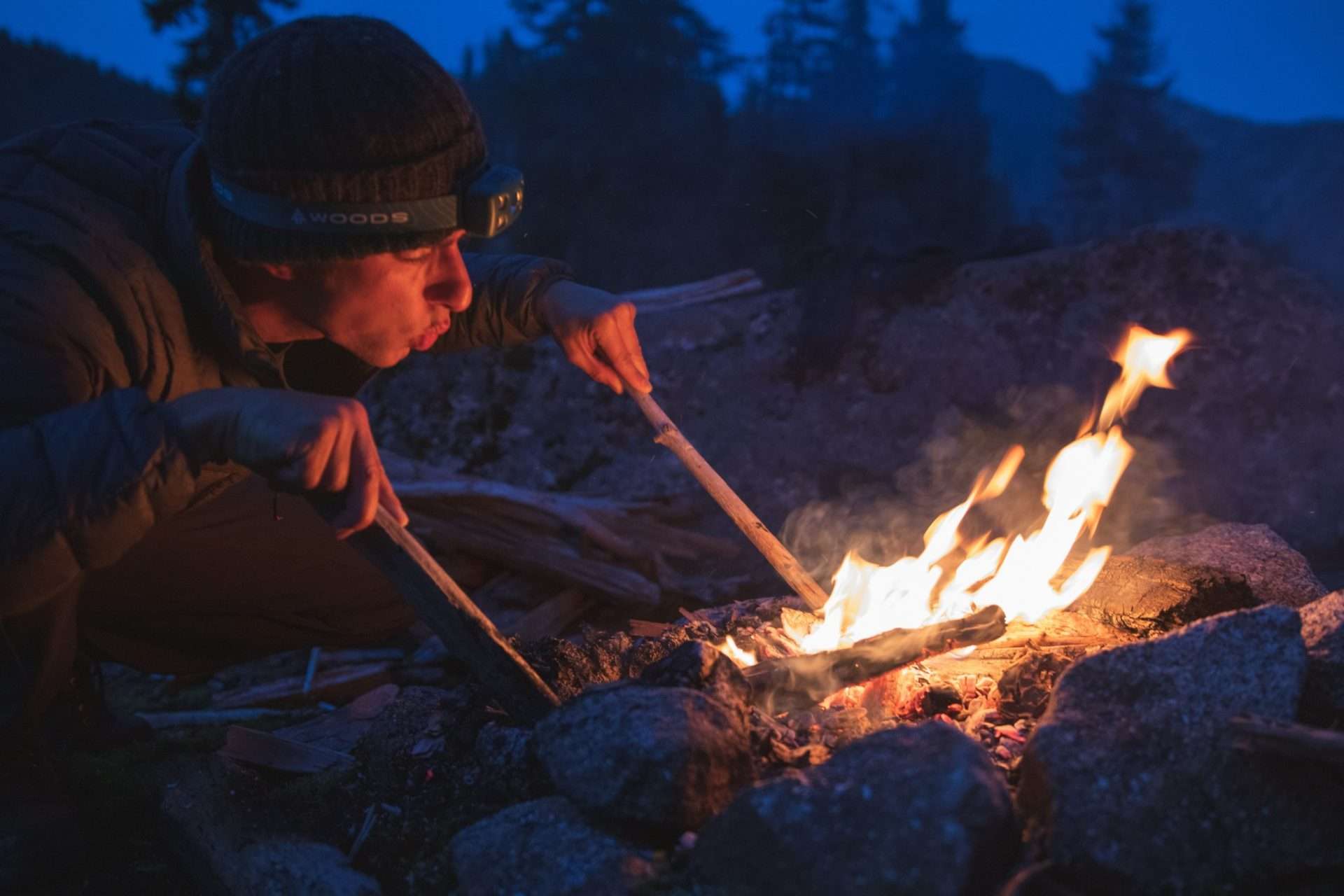 Man building a fire in the wilderness.