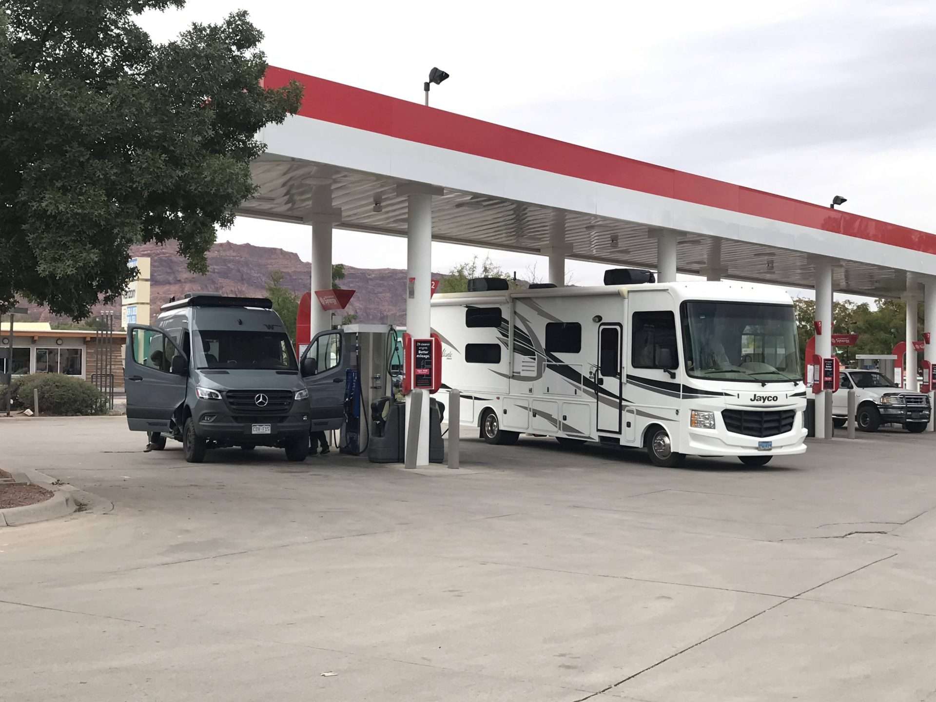 Class B and Class A motorhome at a gas station