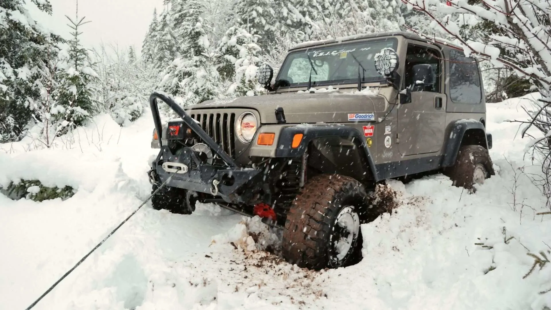 Jeep winching itself out of snow