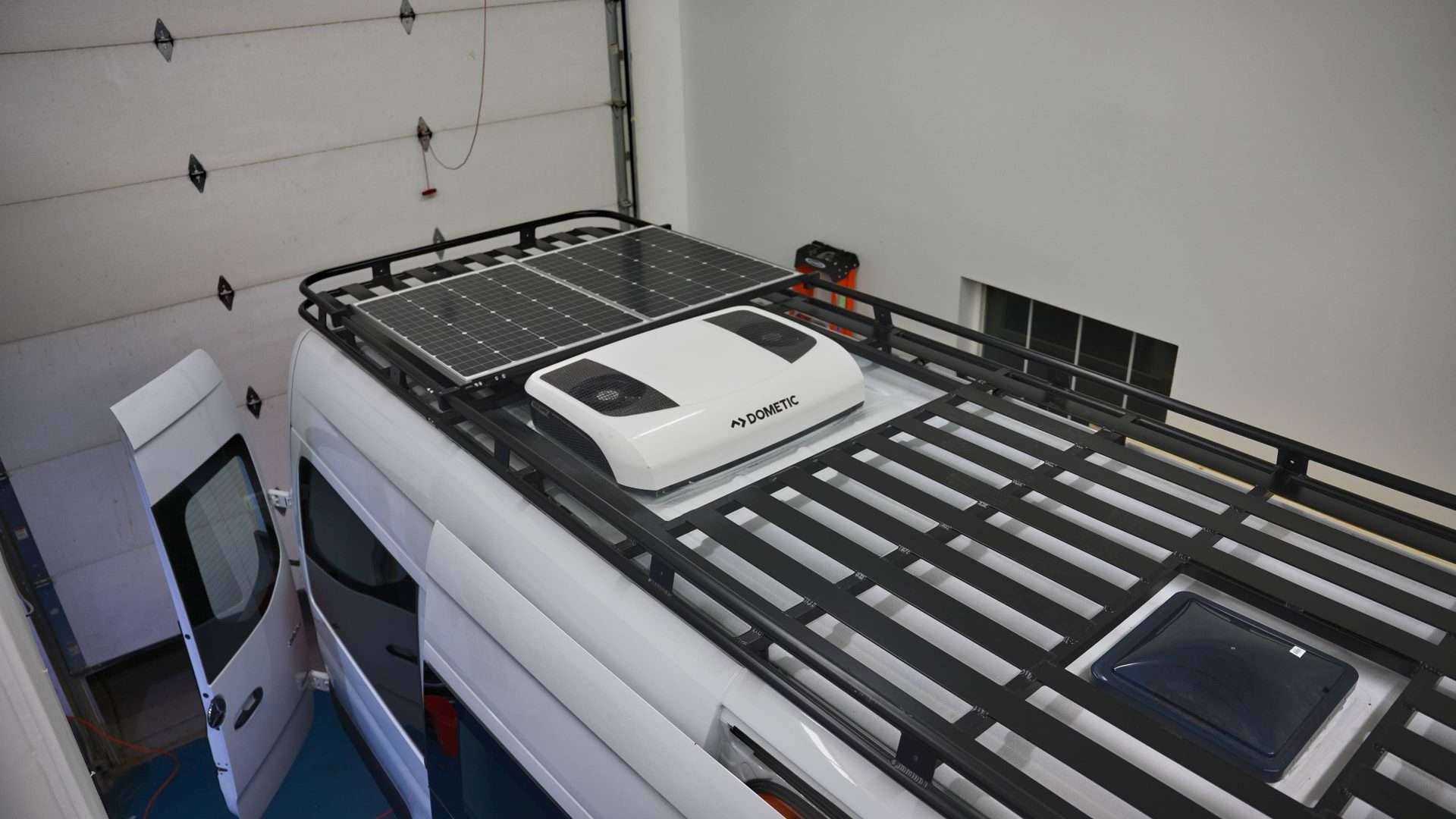 Camper van parked inside with solar panels on top.