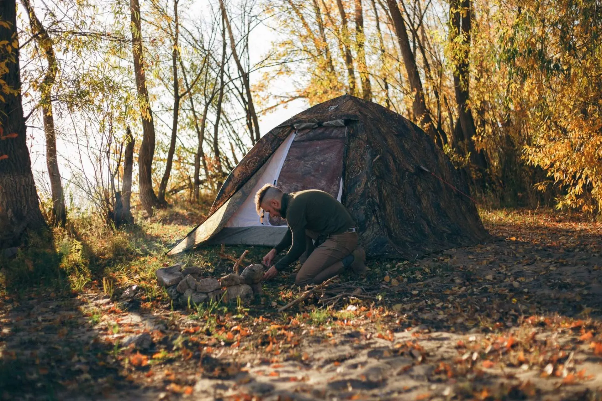 Man setting up camp site in forest.
