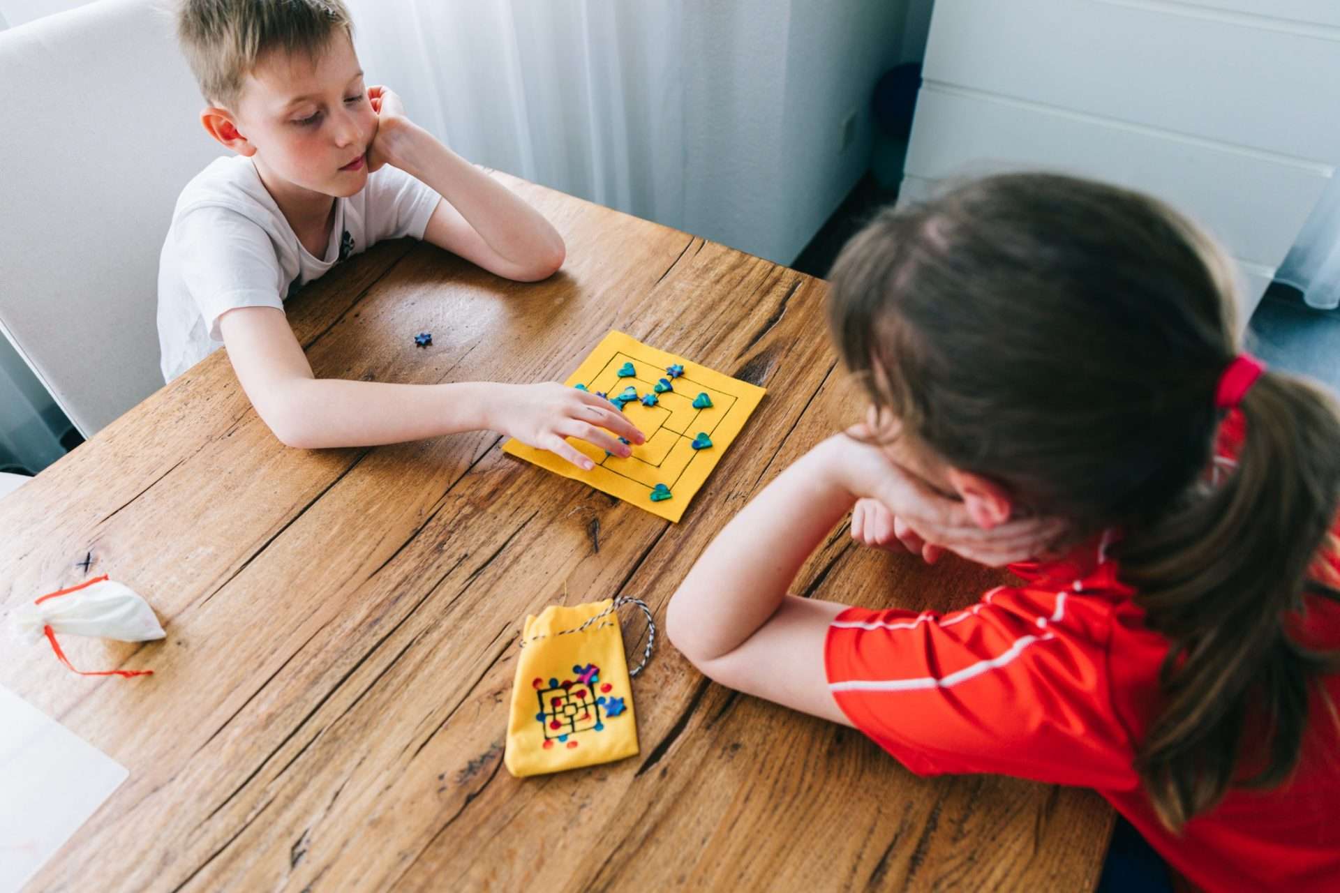 Siblings playing small board game.