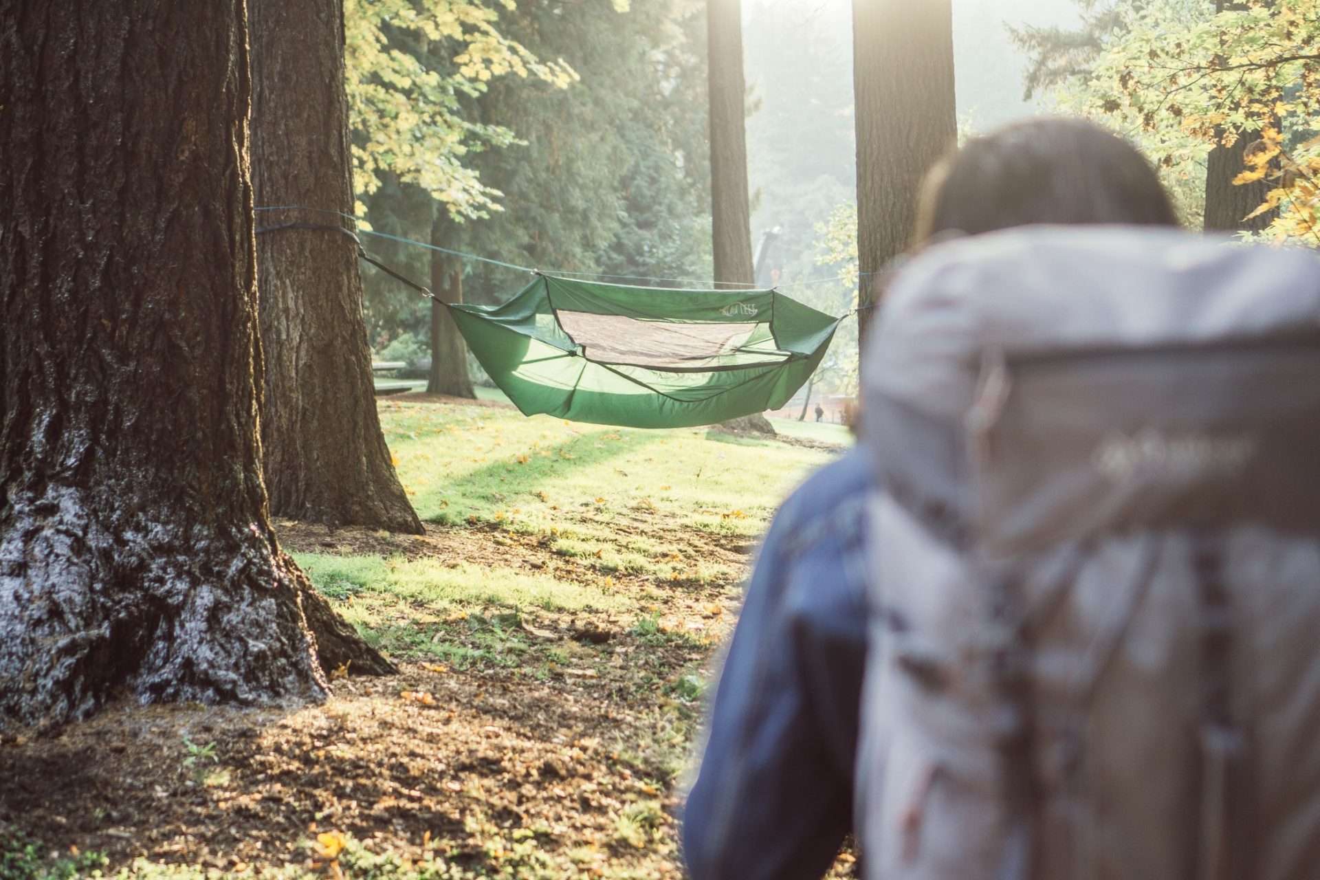 Woman camping with a hammock tent.