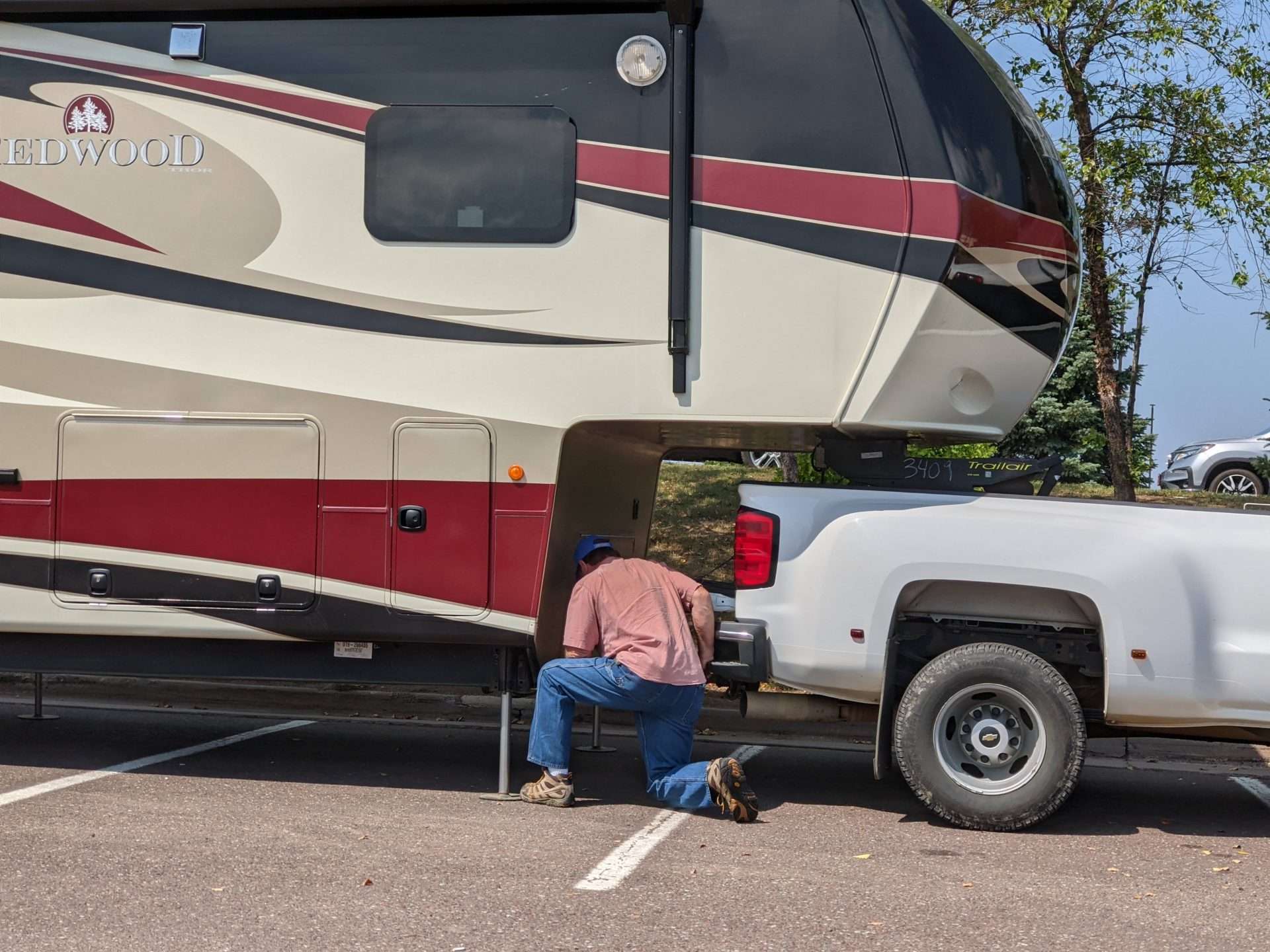Man hitching truck and fifth wheel RV together.