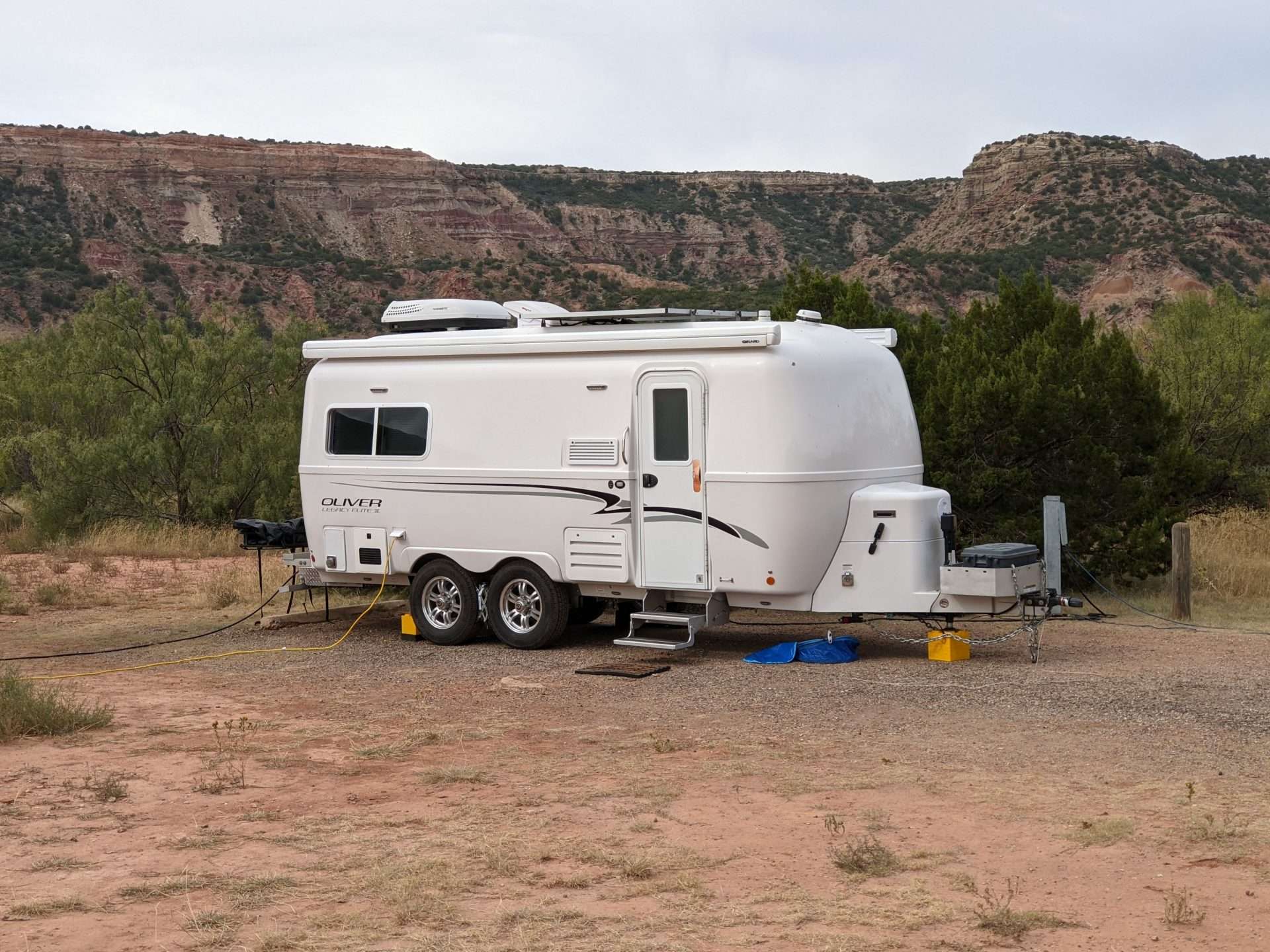 Oliver fiberglass RV camper parked at campsite.