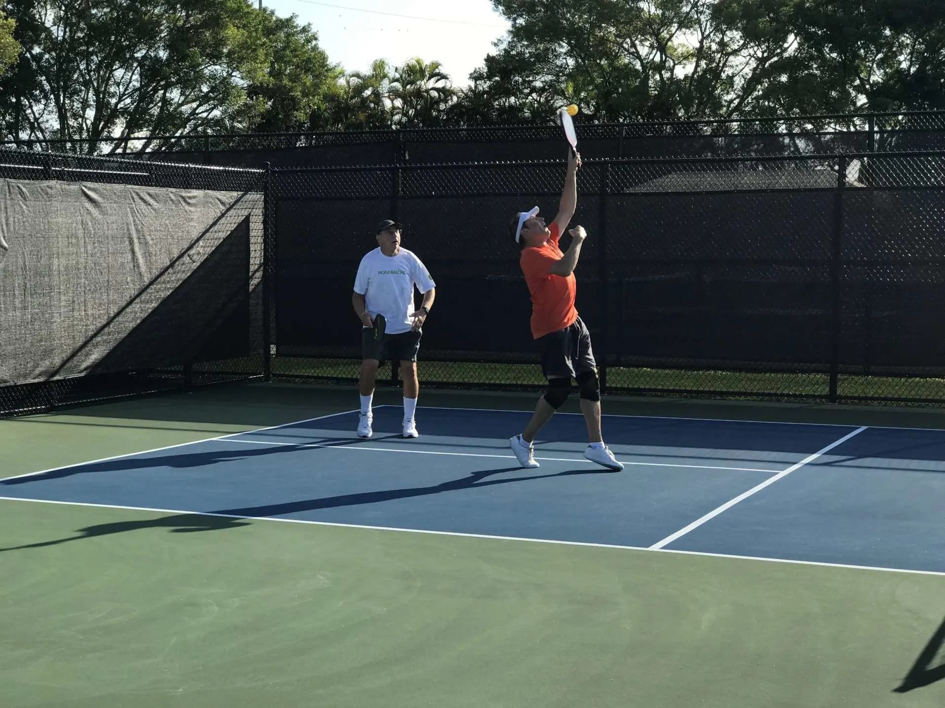 Two men playing pickleball together.