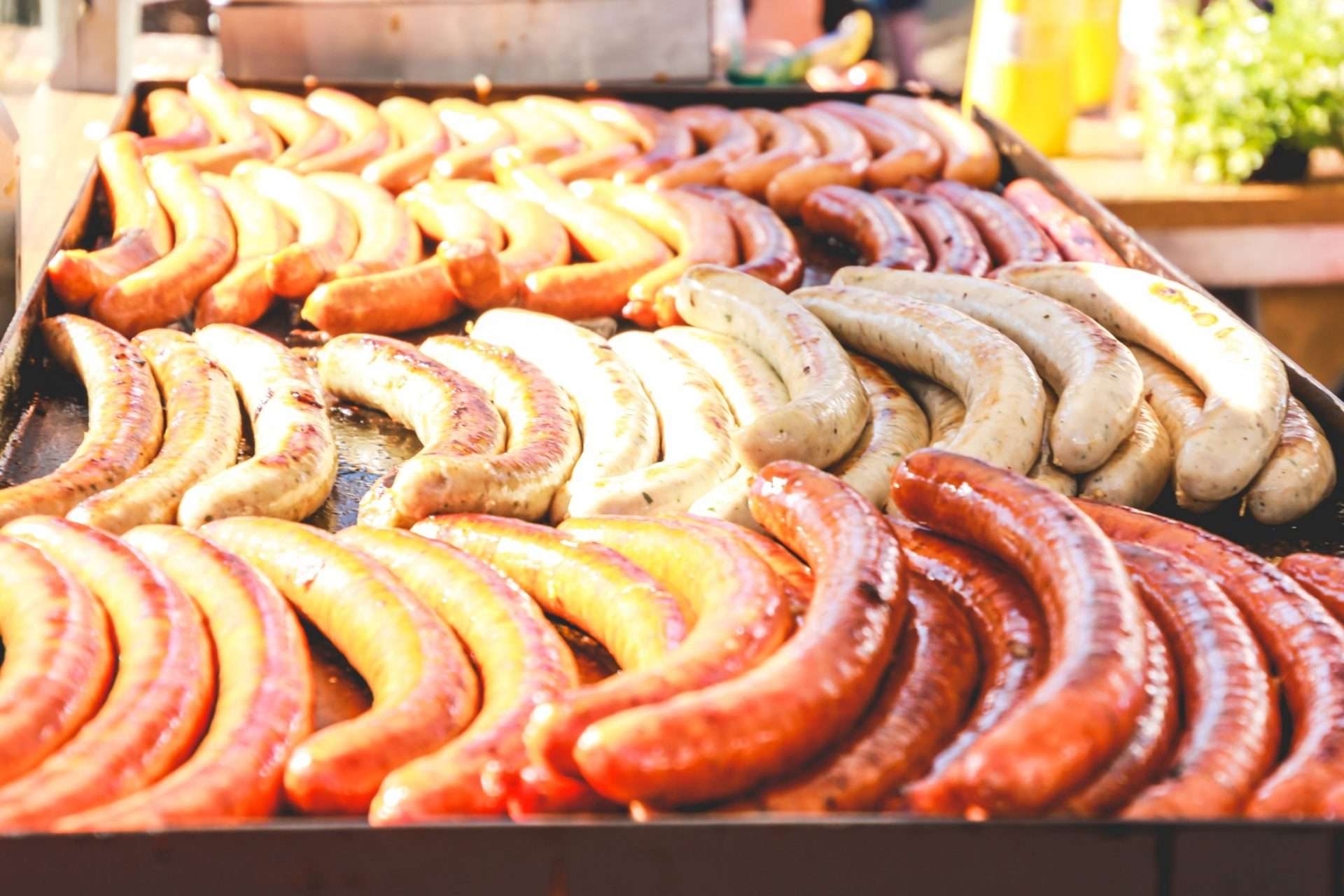 Bratwursts piled up on grill