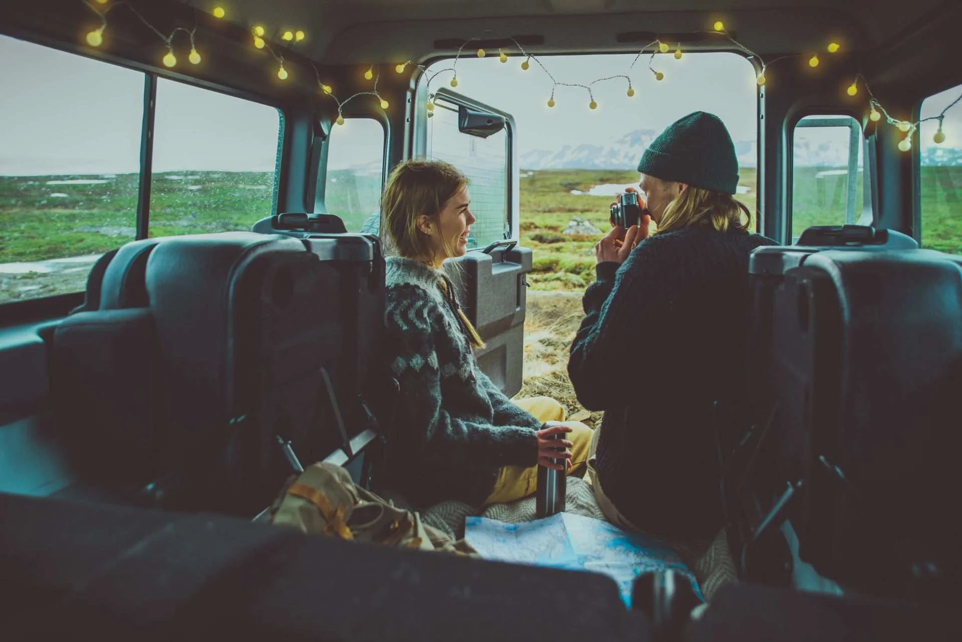 Couple sitting in camper van rental together in Iceland.