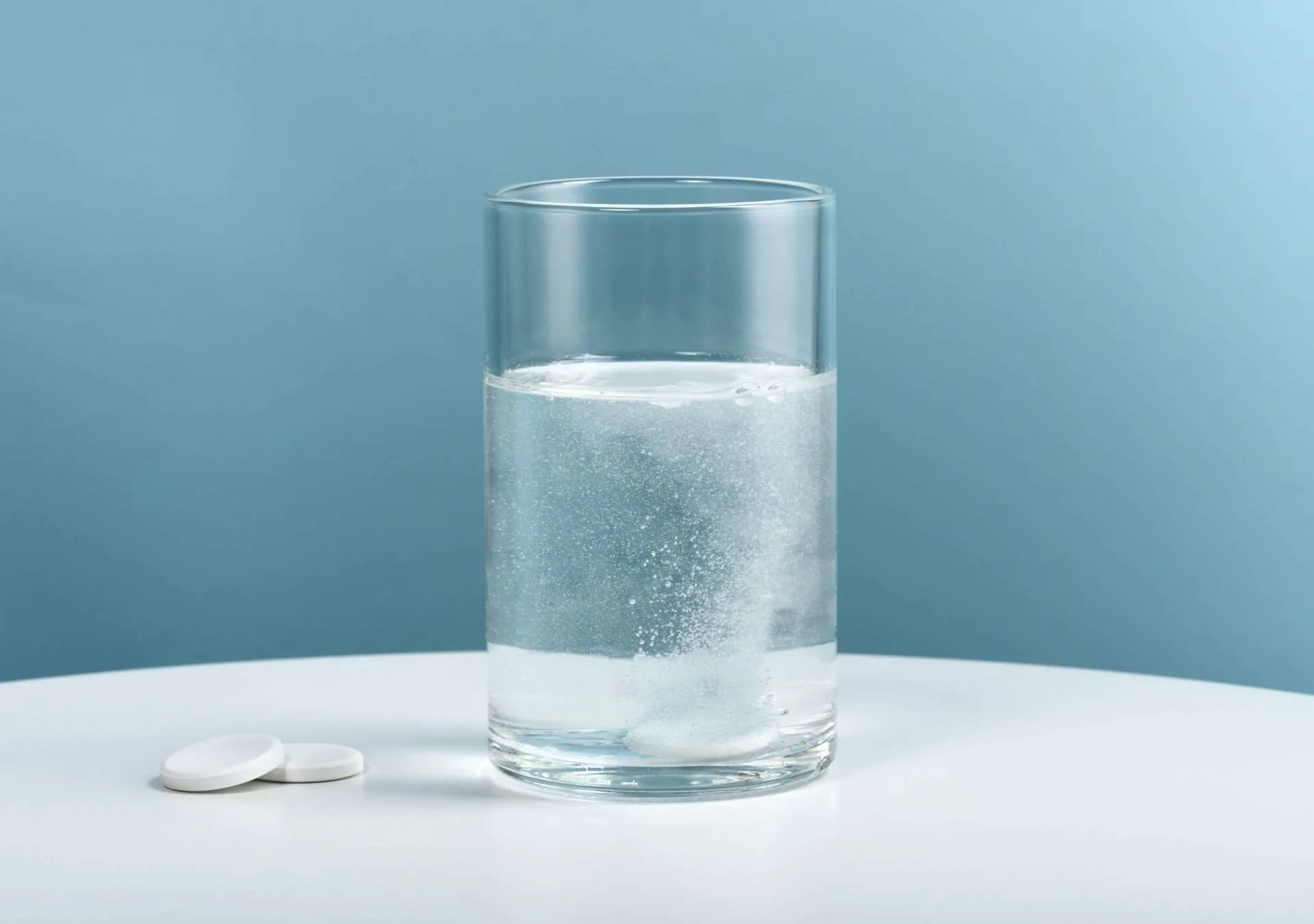 Glass of water with water purification tablet.