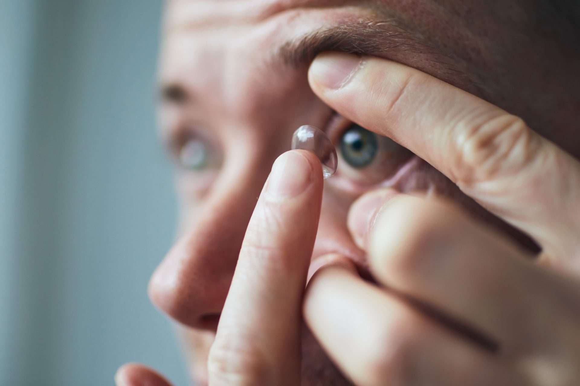 Man putting contact into his eye