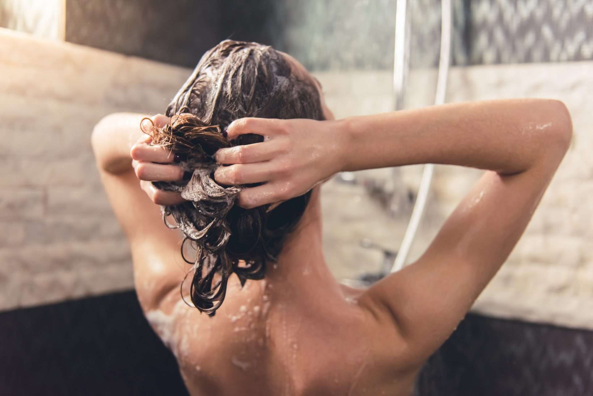 Woman shampooing hair in campground shower